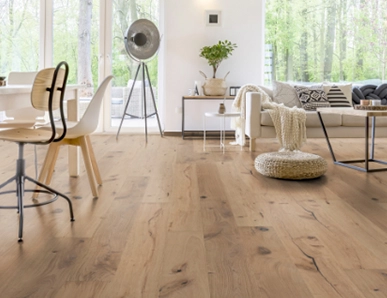 Im Wohnzimmer wurde Parkett in Langdielen-Optik verlegt. Ein Sofa und einige liebevoll platzierte Dekoelemente runden das gemütliche Ambiente ab.