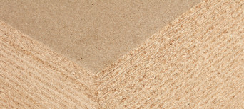 Detailansicht einer Spanplatte mit feiner Holzspanstruktur, ideal für Möbelbau und Innenausbau.