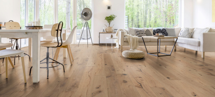 Im Wohnzimmer wurde Parkett in Langdielen-Optik verlegt. Ein Sofa und einige liebevoll platzierte Dekoelemente runden das gemütliche Ambiente ab.