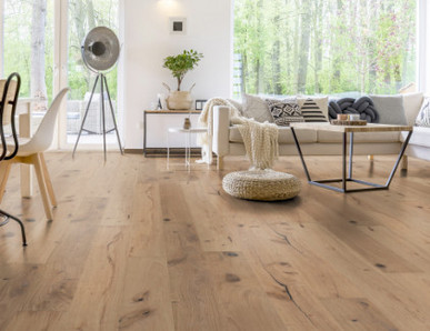 Im Wohnzimmer wurde Parkett in Langdielen-Optik verlegt. Ein Sofa und einige liebevoll platzierte Dekoelemente runden das gemütliche Ambiente ab.