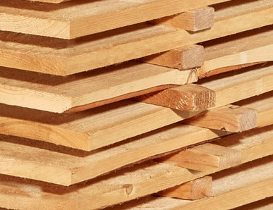 Gestapelte Schalbretter aus Holz mit sägerauer Oberfläche, ideal für den Bau- und Konstruktionsbereich.