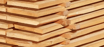 Gestapelte Schalbretter aus Holz mit sägerauer Oberfläche, ideal für den Bau- und Konstruktionsbereich.