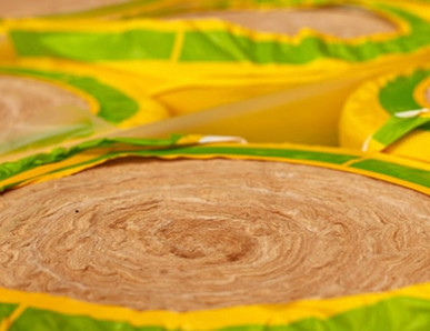 Gerollte Dämmwolle in gelb-grüner Verpackung, bereit für den Einsatz in Wärmedämmung und Schallschutz.